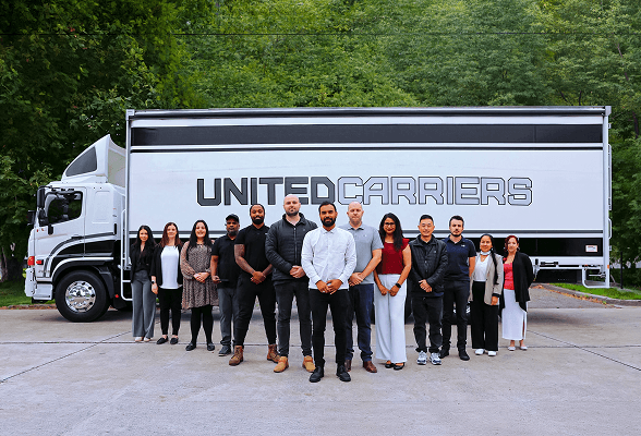 Group of twelve diverse people standing in front of a Tidewell truck outdoors.