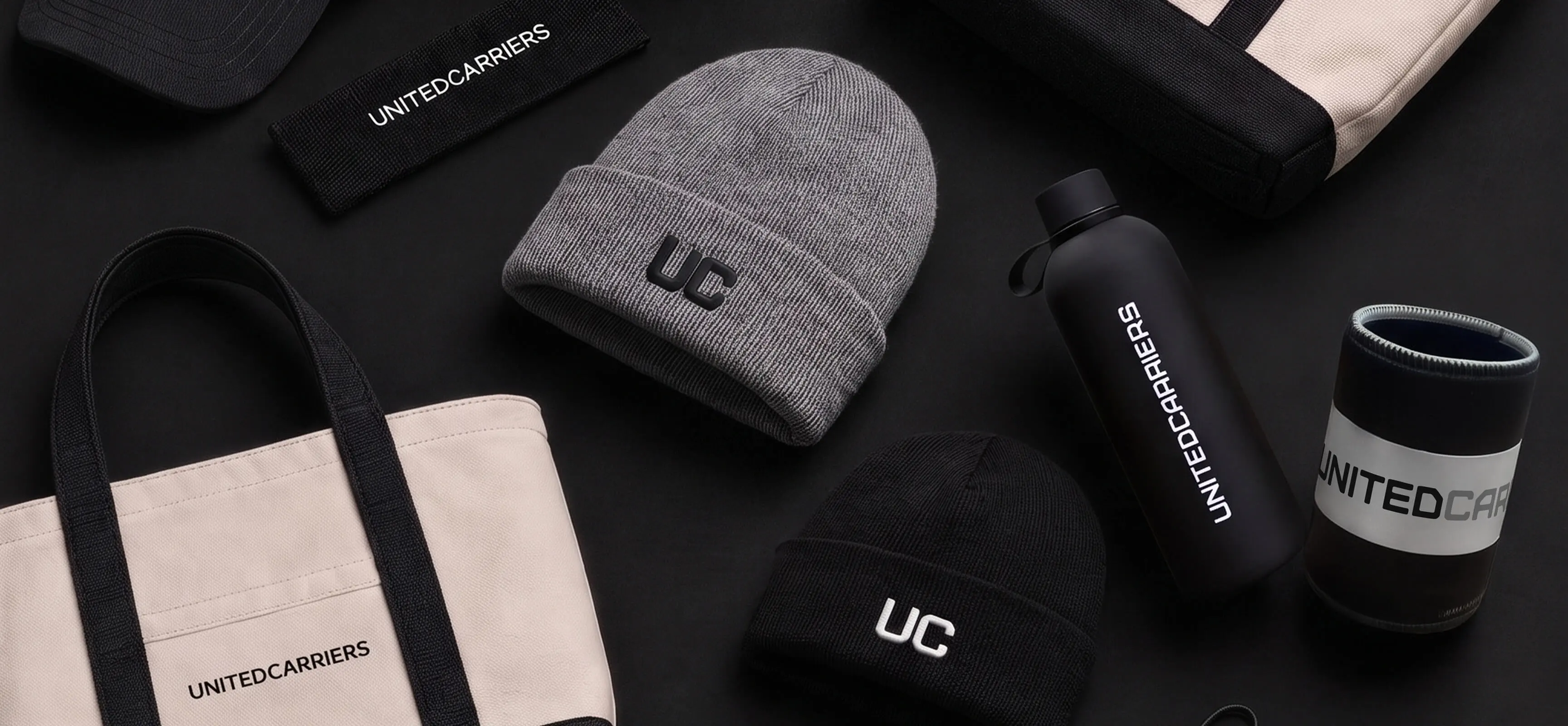 Black and gray beanies, tote bags, water bottle, and sleeve featuring Tidewell branding.